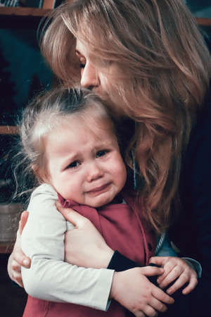 Mother hugging a crying baby. Family care conceptの写真素材