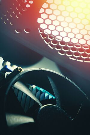 A cooling system of PC. A fan of central processing or the CPU on motherboard cooler pc system unit. Lens glare and toned photoの写真素材