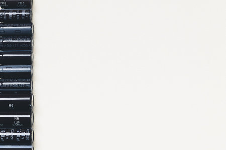 Many capacitors on one side on white background with big copy space, electronics part concept.