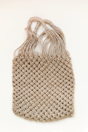 Reusable net bag or mesh shopper on beige