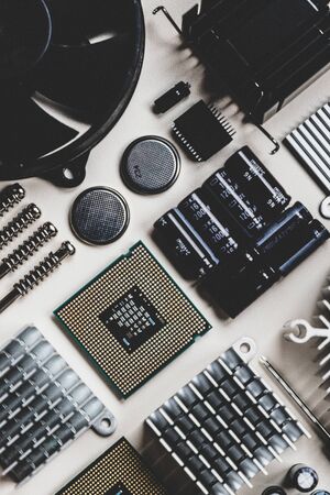 Computer and laptop hardware - CPU, fan cooler, battery, capacitors, radiator, chip on the white background with copy space, flat lay. PC parts top view. Repair, assembly, engineering concept.の写真素材