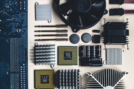 Top view of computer parts with CPU, fan cooler, battery, capacitors, radiator, chip, screwdrivers on white table background with copy space. DIY constructor conceptの写真素材