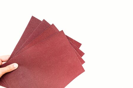 sandpaper in hand isolated on white background.の写真素材