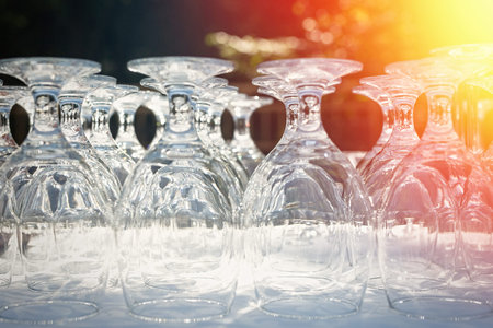 Wine glasses on a table outdoor. Focus blurred foreground, defocused background bokeh, light optical...