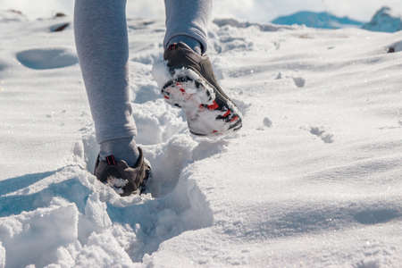 The legs of a woman in sporting winter shoes in deep snow.の写真素材