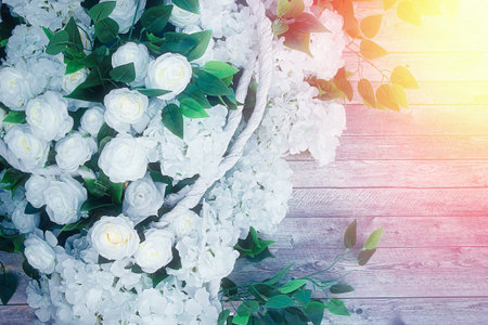 White flowers and green leaves on wooden background. Wedding background.の写真素材