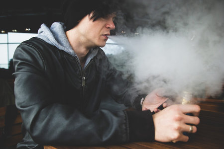Young vape steamer smoker exhaling big cloud of steam.の写真素材