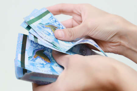The women hand holds the national currency of Kazakhstan tenge.の写真素材
