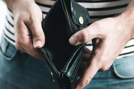 Man's hand holding an empty black wallet.