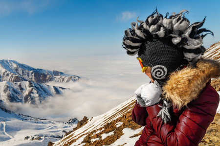 Funny mohawk hat woman in mountains traveling. Winter traveling scene, wanderlust concept.