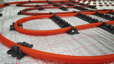 Installation of underfloor heating pipes on a heat reflecting membrane.の写真素材