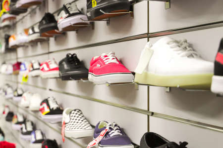 Various brand of shoes for sale on supermarket stand or shelf. Selective soft focusのeditorial素材