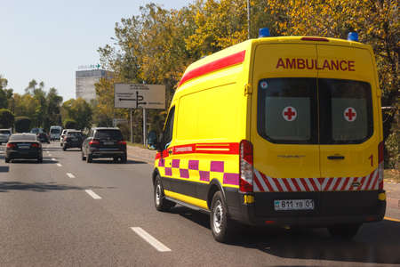 An ambulance car rides along Almaty street Al-Farabi in a heavy traffic.のeditorial素材