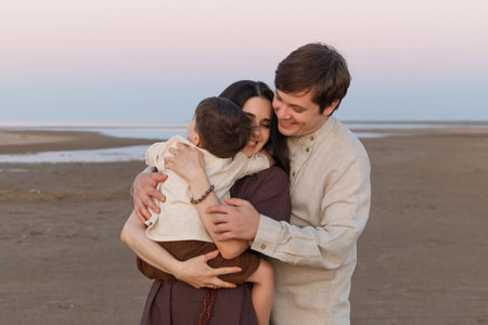 Family hugs on the evening beach. Family look linen clothesの写真素材