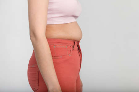 Side view of belly of a slightly overweight young woman. Diet, overweight, obesity conceptの写真素材