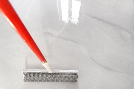 Needle roller tool for self-leveling floor. Copy space on liquid floor surface.の写真素材