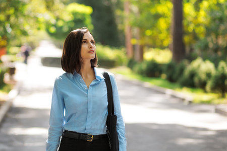 Beautiful brunette woman walking in the park on a summer sunny day