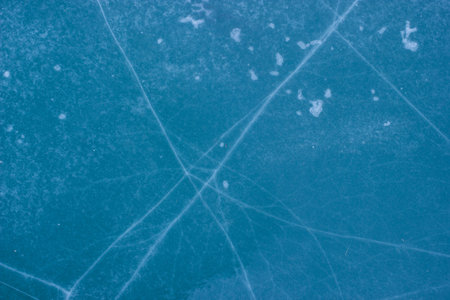 Blue cracked surface of frozen lake background.
