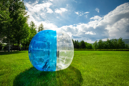 Zorbing Balloon on the summer lawn. inflatable zorb ball outdoor. Leisure activity concept with copy...