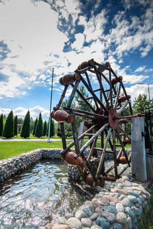 Decorative garden pond with with jugs on a movable wheel on an electric motor. Vertical. copy space.