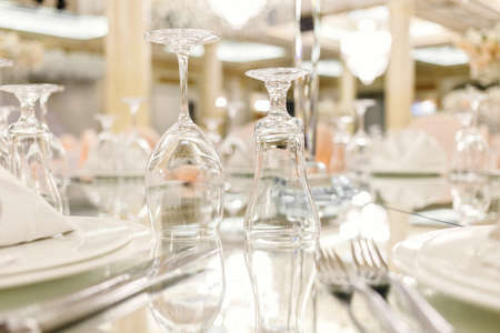 Mirror table festive setting in luxury restaurant. Glasses, plates, cutlery on mirror table. shallow depth of fieldの写真素材