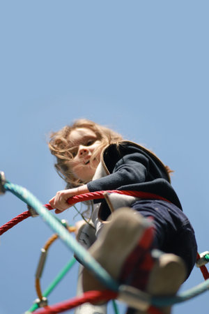 Cute little girl at the playground look at camera from above. Copy space Vertical, Selective soft...