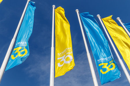 Blue and yellow holiday flags against the background of a clear sky in honor of the 30th anniversary...