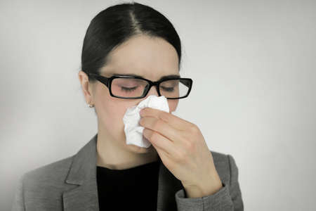 Young woman wearing glasses with flu symptoms.の写真素材