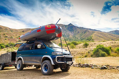 Almaty, Kazakhstan - August 04, 2021: Rafting boat on the roof of a Mitsubishi Delica car on mountainous terrainのeditorial素材