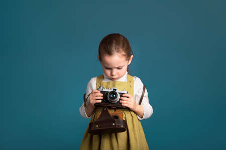 Pensive serious little girl intends to learn to photograph.の写真素材