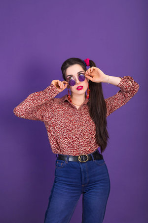 Smiling young brunette woman in 90s style with round shape sunglasses with copy space vertical.