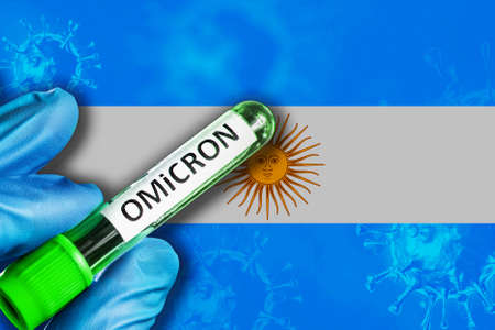 Argentina outbreak of omicron variant. A hand in a blue rubber glove holds a test tube with covid-19 virus omicron in front of Argentina flag. Omicron variant outbreak conceptの写真素材