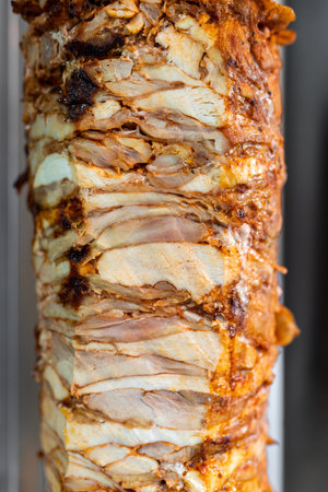 Close-up of vertical skewer chicken meat for Doner Kebab, Turkish street food.