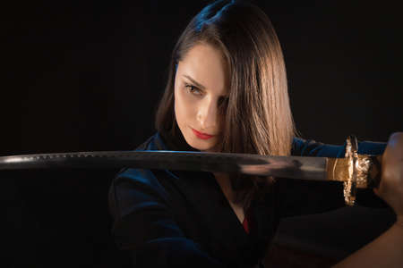 Young brunette warrior woman with katana sword.の写真素材