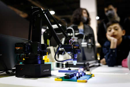 Conveyor-type robot mounting chips at the exhibition stand of the robot festival. Almaty, Kazakhstan - February 19, 2022のeditorial素材