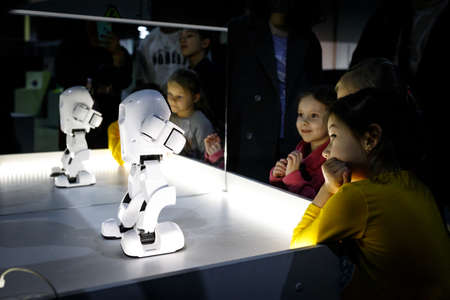 Children around the white robot at the robot festival booth. Almaty, Kazakhstan - February 19, 2022のeditorial素材