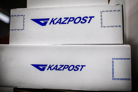 Parcel cardboard boxes with the Kazpost logo in the office. Almaty, Kazakhstan - November 17, 2021