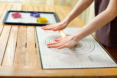 Woman using culinary silicone mat for cooking homemade baking.の写真素材