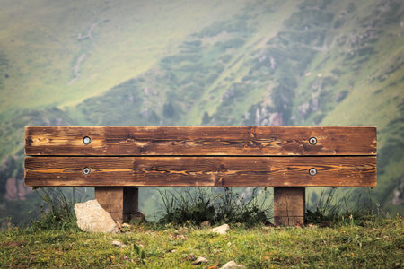 Wooden bench with a view of the mountains in a touristic hiking trail, copy space.の写真素材