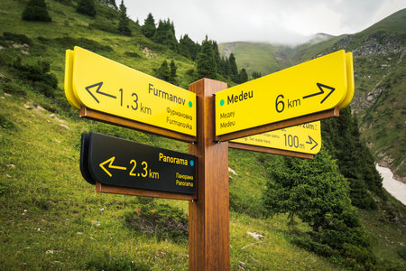 Tourist signpost for tourists with indications of directions and range of the route in the mountains of Almaty. Almaty, Kazakhstan - July 19, 2022のeditorial素材