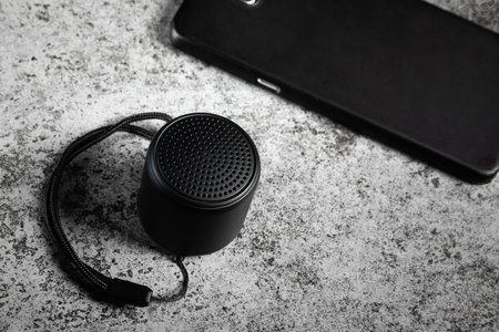 Black mini speaker and smartphone conected.