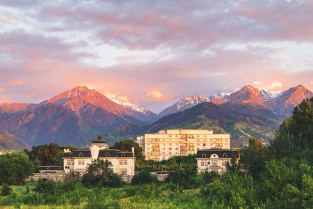 Multi-storey residential buildings immersed in the summer greenery of the city of Almaty at sunset, located in the foothills of Central Asia. Almaty, Kazakhstan - June 18, 2022のeditorial素材