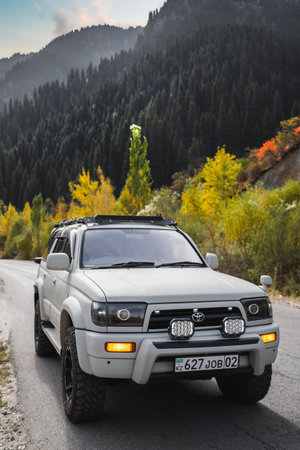 Off-road white car Toyota on autumn mountain road trip. Almaty, Kazakhstan - September 28, 2022