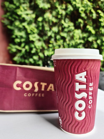 Signature paper cup and paper bag of Costa Coffee on the table of a street coffee shop. Almaty, Kazakhstan - October 08, 2022.のeditorial素材