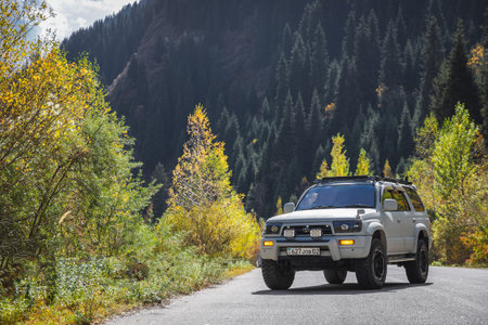 Japanese off-road used white car Toyota Hilux Surf on autumn mountain road. Almaty, Kazakhstan -...