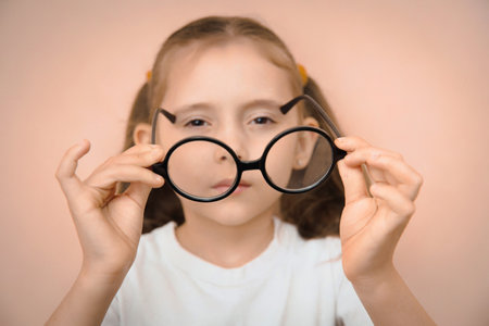A little kid girl of elementary school age to choose the right glasses with a diopter.の写真素材