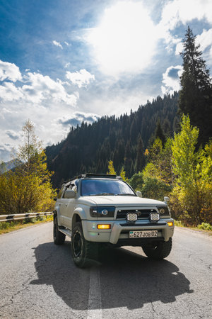 Japanese off-road used white 4x4 car Toyota 4runner on autumn mountain road trip, copy space, vertical. Almaty, Kazakhstan - September 28, 2022のeditorial素材