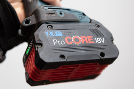 18 volt battery Pro Core on a cordless drill in the workers hand. Almaty, Kazakhstan - Marth 18,...