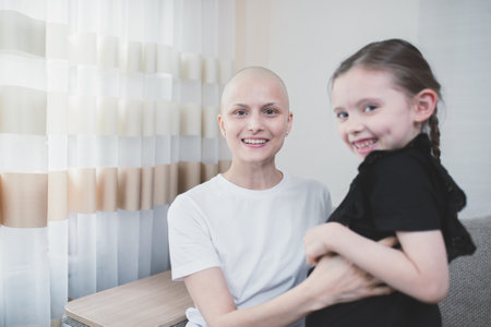 Happy bald woman with alopecia smiling and joyful spending time with her daughter.の写真素材