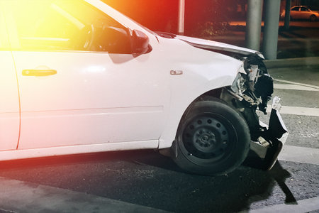 Broken car after a frontal collision, side view of a night accident.の写真素材